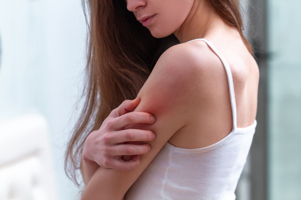 Young woman suffering from itching on her skin.