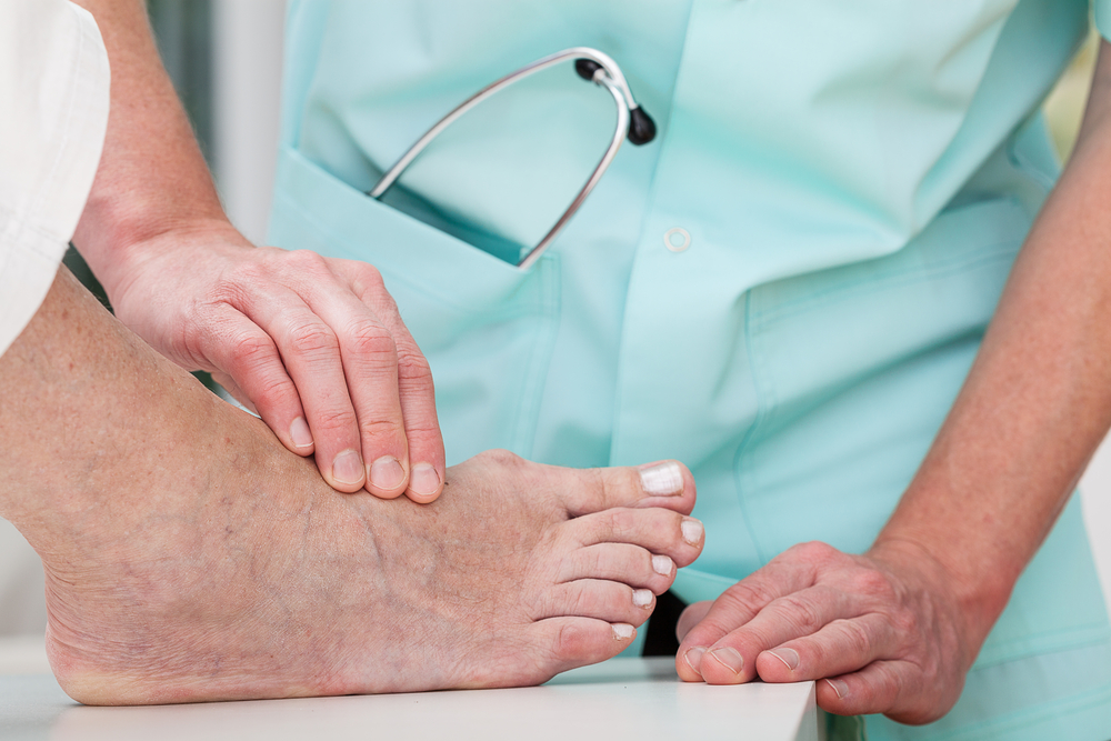 Dermatologist looking at patient's foot.