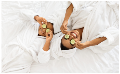 Mom and daughter laying with cucumber slices on their eyes.